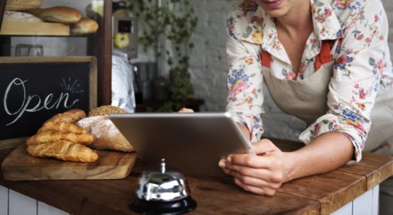 Femme tenant un petit commerce sur sa tablette