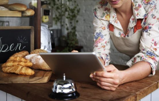 Femme tenant un petit commerce sur sa tablette