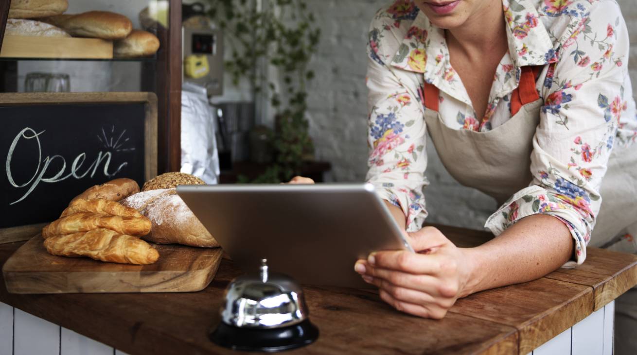 Femme tenant un petit commerce sur sa tablette